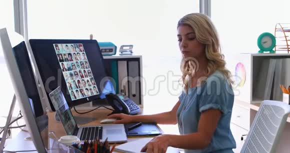 女行政人员在办公桌前工作时使用手机视频的预览图