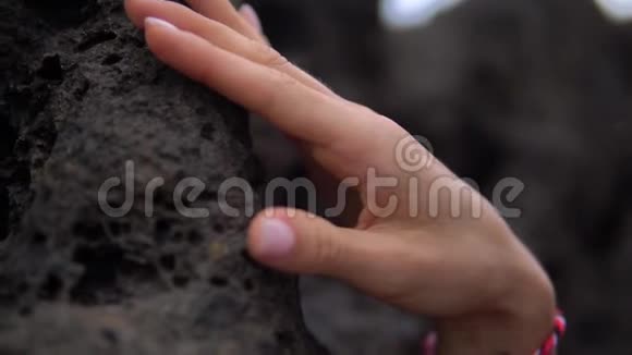 女子手与浅色指甲和漂亮的美颜触摸黑石视频的预览图