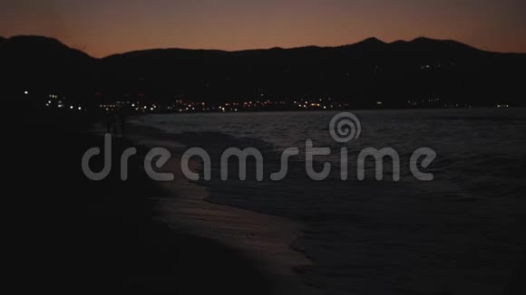 傍晚时分一对夫妇沿着海岸散步视频的预览图