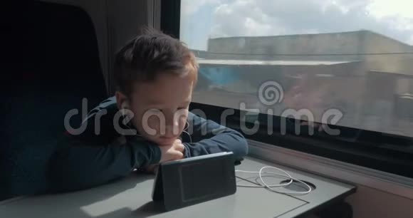 带着耳机的小孩在火车上看卡通视频的预览图