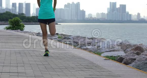 女跑步者在海边热身和跑步视频的预览图