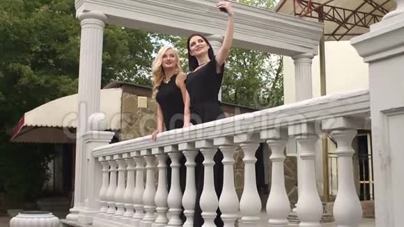 两个穿黑色晚礼服的女孩自拍视频的预览图