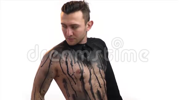 一个肌肉发达的男人穿着碎衬衫和身体艺术纠正他的头发慢动作视频的预览图
