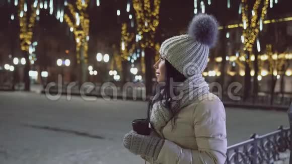 圣诞节晚上在街上拿咖啡杯的女孩视频的预览图