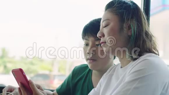 快乐的妈妈和儿子在餐厅用电子设备聊天和玩耍视频的预览图