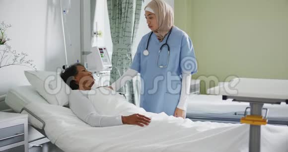 年轻医生在病床上与病人交谈视频的预览图