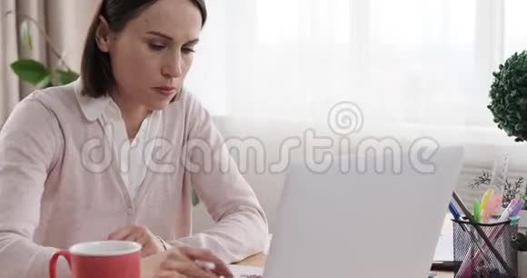 女商人使用笔记本电脑在办公室做笔记视频的预览图