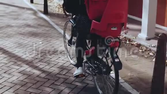 慢动作脚踩踏板特写快乐的女人骑着城市自行车休闲沿街骑行视频的预览图
