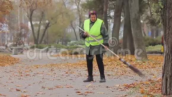 劳累的妇女在街头做清洁工低工资的体力劳动贫穷视频的预览图
