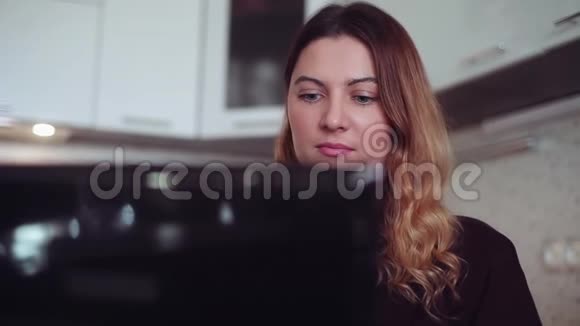 特写镜头漂亮的年轻女孩心情很好在笔记本电脑上打字家庭风格视频的预览图