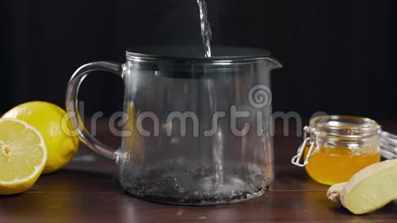 将沸水倒入茶壶中加入红茶柠檬生姜和蜂蜜的维生素茶以防生病视频的预览图