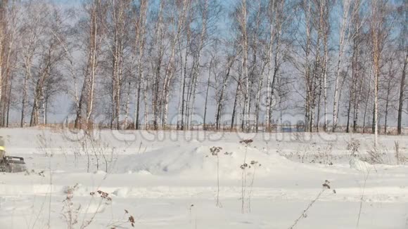 穿着冬天衣服的人在迷你雪车上克服大雪在乡间的漂流中跳跃视频的预览图