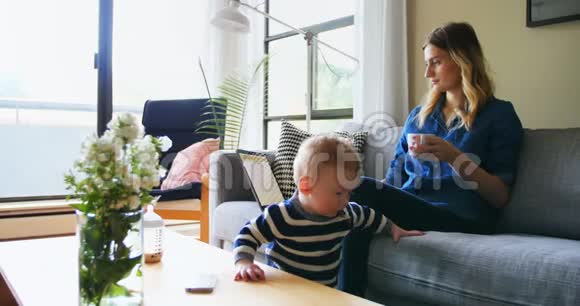 母亲在照顾儿子时使用笔记本电脑视频的预览图