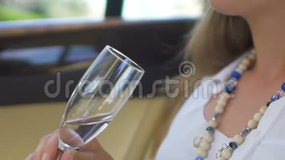 年轻女士穿着优雅的衣服享受着一杯清爽的葡萄酒乘车旅行视频的预览图