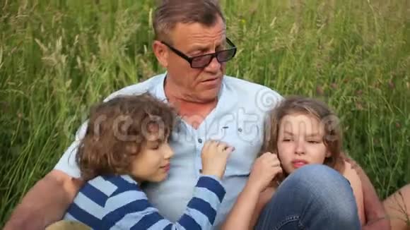 一个成熟的男人和他的孩子一个男孩和一个女孩晚辈晚辈亲子关系父亲节视频的预览图