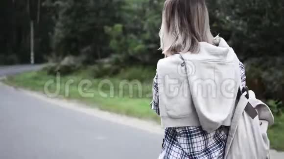 美丽的女孩走在路上女孩旅行视频的预览图