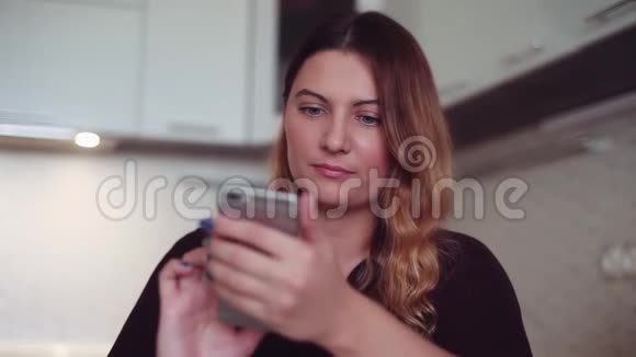 漂亮的年轻女孩用智能手机上网家庭风格高清高清视频的预览图