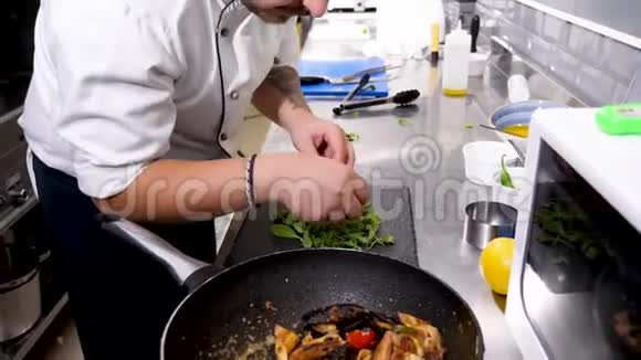 厨师手拿钳子把海鲜放在餐盘上视频的预览图
