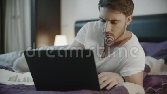 闲杂人在家里用手提电脑在线工作严肃的男人工作笔记本视频的预览图