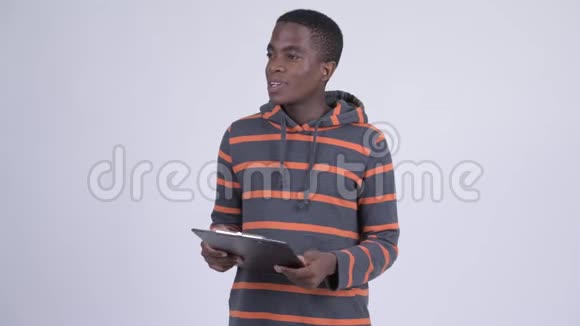 年轻快乐的非洲男人一边说话一边看剪贴板视频的预览图