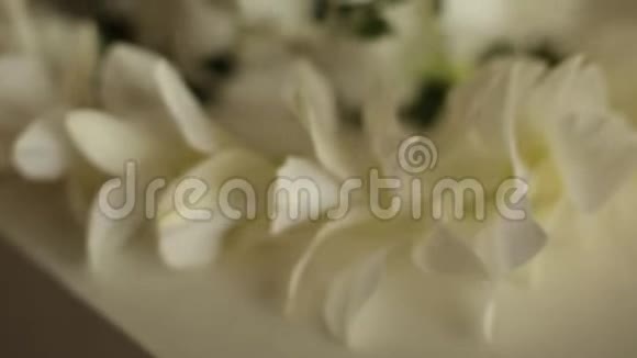 一种传统的夏威夷雷花圈由白色兰花在婚礼前的桌子上制成宏观镜头视频的预览图