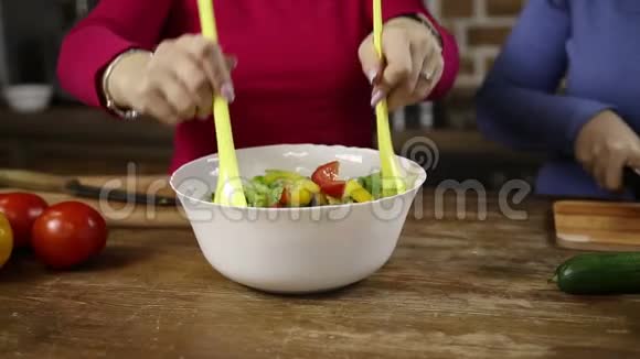 女人搅拌一碗新鲜蔬菜沙拉视频的预览图