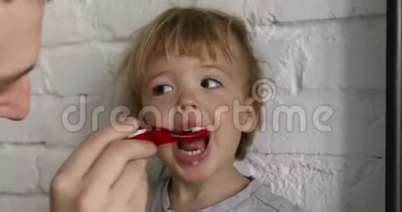 父母刷他的小男孩牙齿视频的预览图