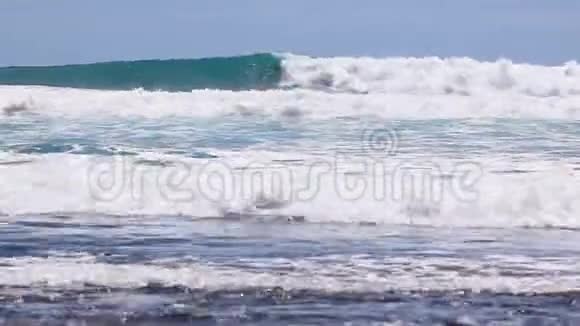 大西洋上的一波又一波缓慢的海浪冲向特内里费的黑色卵石海岸视频的预览图