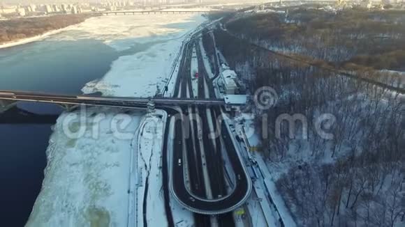 在冬季城市的高速公路路口驾驶的空中观景车雪城景观视频的预览图
