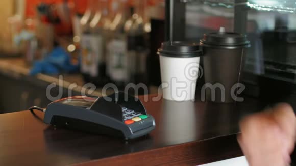 咖啡馆里穿夹克的商人用智能手表和终端机来支付价格视频的预览图