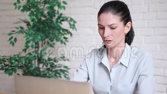 愤怒的年轻女商人大声喊叫她的笔记本电脑视频的预览图