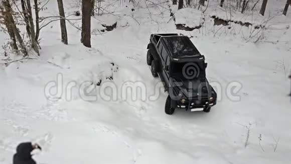 越野车要从深坑里骑出来在白雪覆盖的道路上冬天的森林非公路视频的预览图