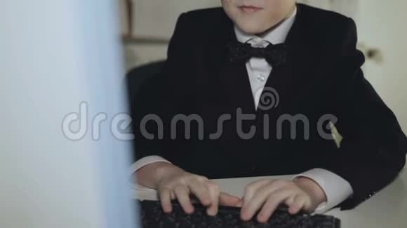 穿西装的小男孩玩电脑游戏并在办公室获胜4K视频的预览图