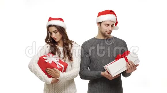 年轻夫妇穿着毛衣拿着礼物像个白人背景的孩子一样对待视频的预览图