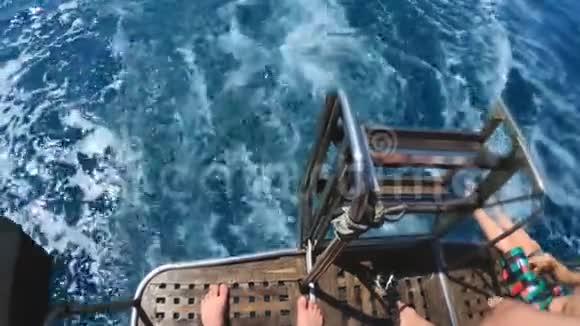 英俊的年轻人坐在海里或海里双腿从船或游艇上下来带水的飞机飞喷视频的预览图