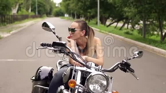 坐在摩托车座椅上的漂亮女摩托车手视频的预览图