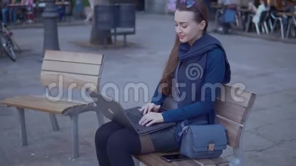 优雅的年轻女子坐在户外的城市广场上视频的预览图