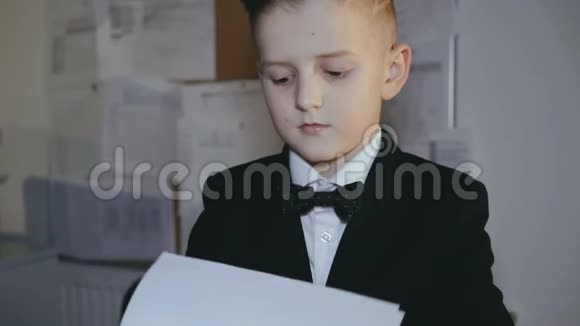 穿西装的小男孩的肖像在办公室里对着镜头微笑4K视频的预览图