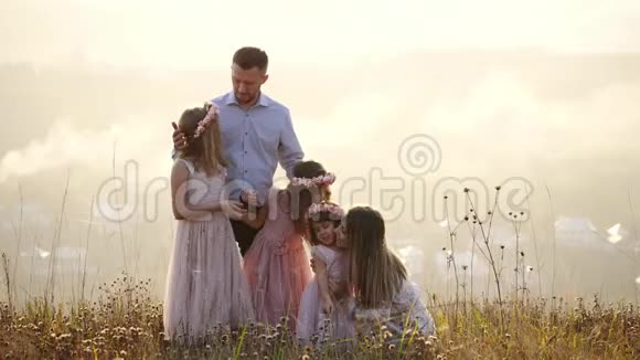 幸福的家庭和他们的面团坐在草地上的肖像视频的预览图