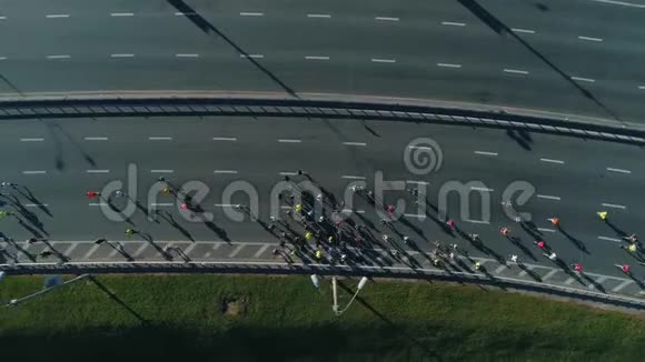 空中无人机在公路桥上跑马拉松顶部视图视频的预览图