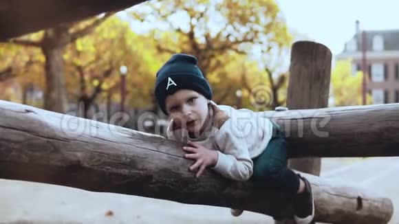 可爱的小男孩在冒险公园玩得很开心困惑紧张的孩子戴着帽子犹豫不决卡在绳索上的障碍物上视频的预览图