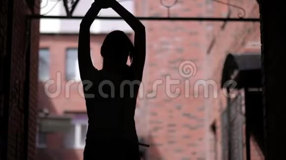 城市建筑背景上跳舞女孩的剪影无拘无束的户外乐趣视频的预览图