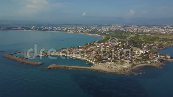 用停泊的船只和低矮的建筑物绕半岛飞行德隆飞向岸边海景和海景视频的预览图