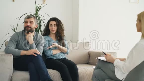 年轻夫妇访问专业心理学家办公室一个古怪的女人愤怒地和她的男朋友争吵视频的预览图