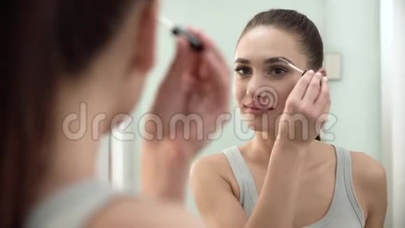 化妆浴室镜子里的女人刷牙视频的预览图