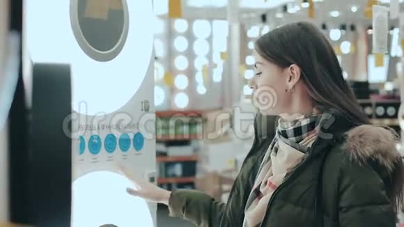 电器和灯具商店里的年轻女子这位女士为她的房子的内部选择物品家庭视频的预览图