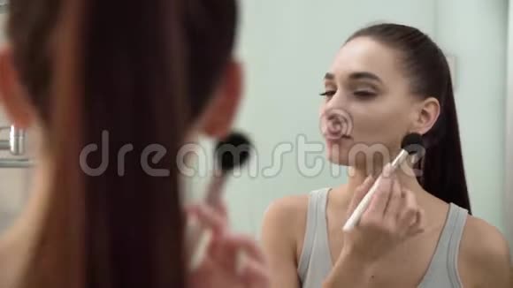 化妆女人用粉末照镜子视频的预览图