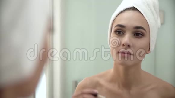化妆浴室镜子里的女人刷牙视频的预览图