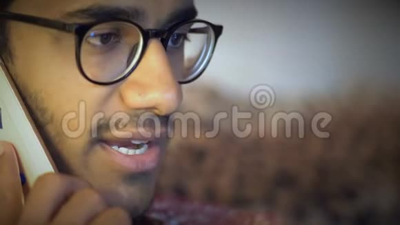 特写镜头戴眼镜的印度男人通过电话讨论商业问题视频的预览图