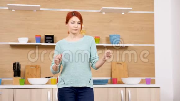 快乐而积极的女人在厨房跳舞视频的预览图